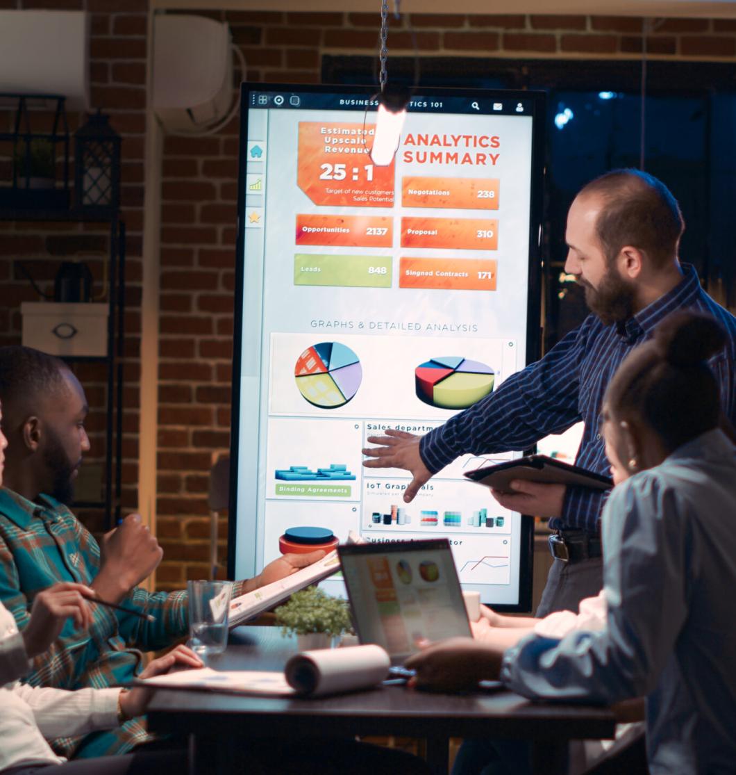 Company analyst explaining statistics graphs visualization, giving presentation in business meeting, holding digital tablet. Employees discussing marketing research analytics. Handheld shot.